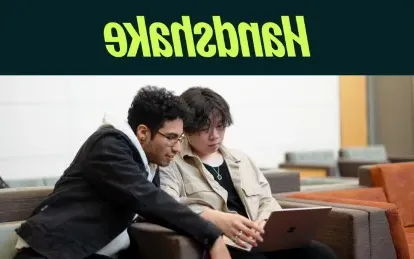 两个学生在看笔记本电脑 